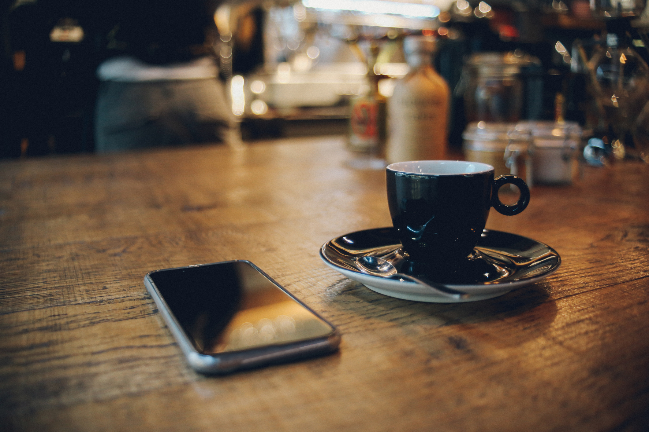 A phone and an espresso cup lay on the table.